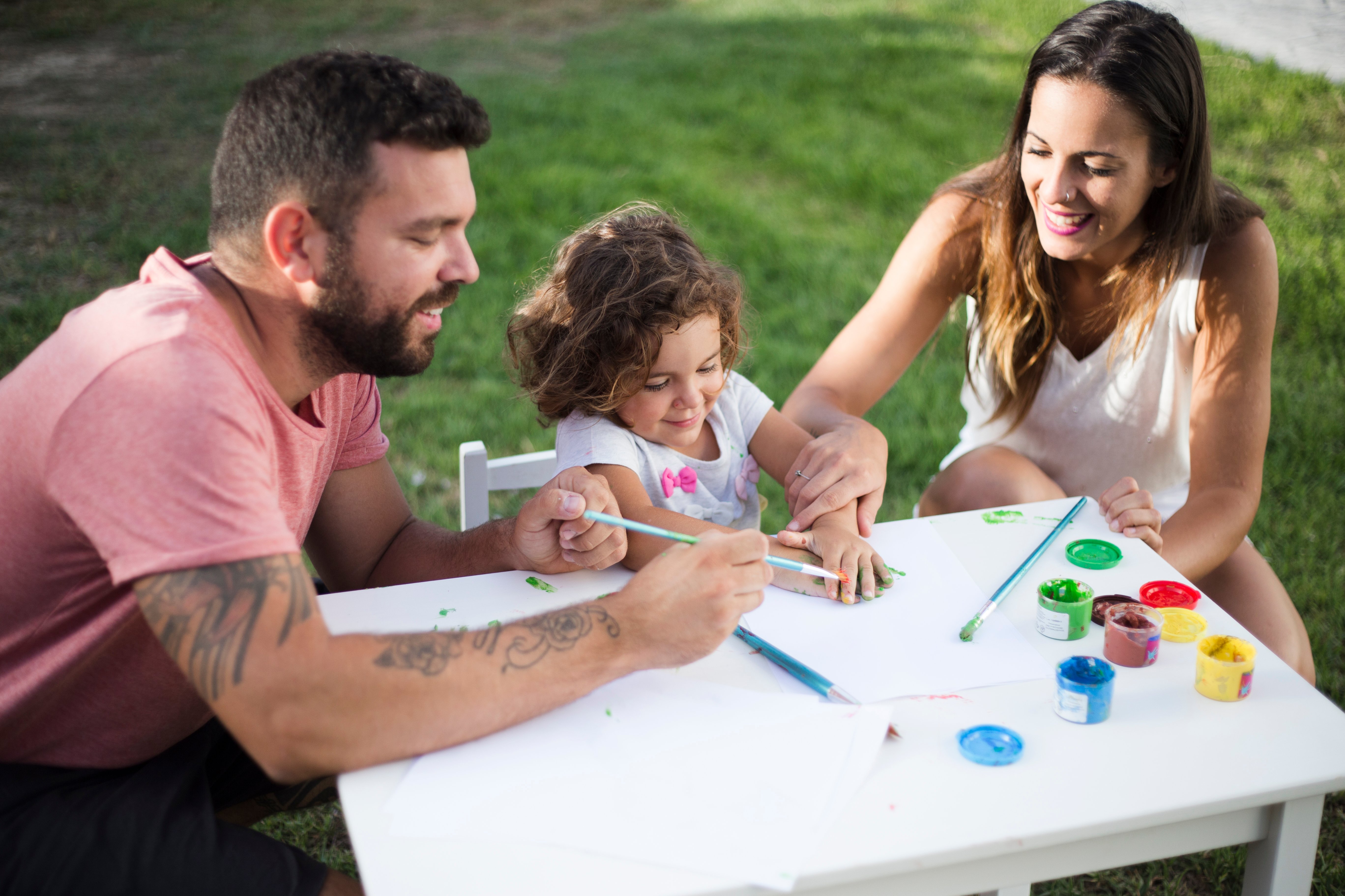 parents-with-their-daughter-painting-together-in-park